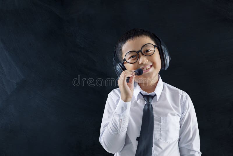 Petit garçon comme un sourire d'opérateur de centre d'appels à la caméra image stock