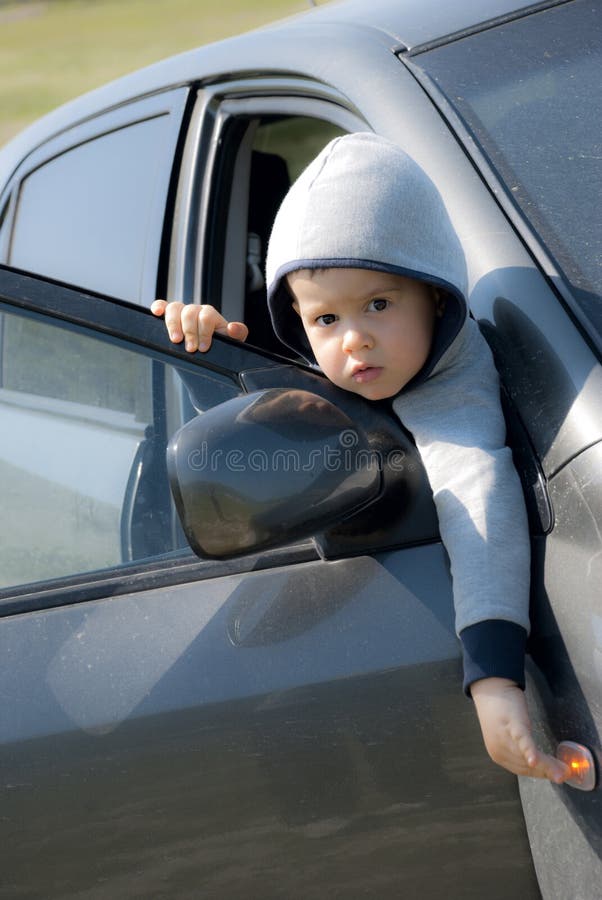Petit garçon doux regardant de la voiture photographie stock libre de droits Petit garçon doux regardant de la voiture photographie stock libre de droits