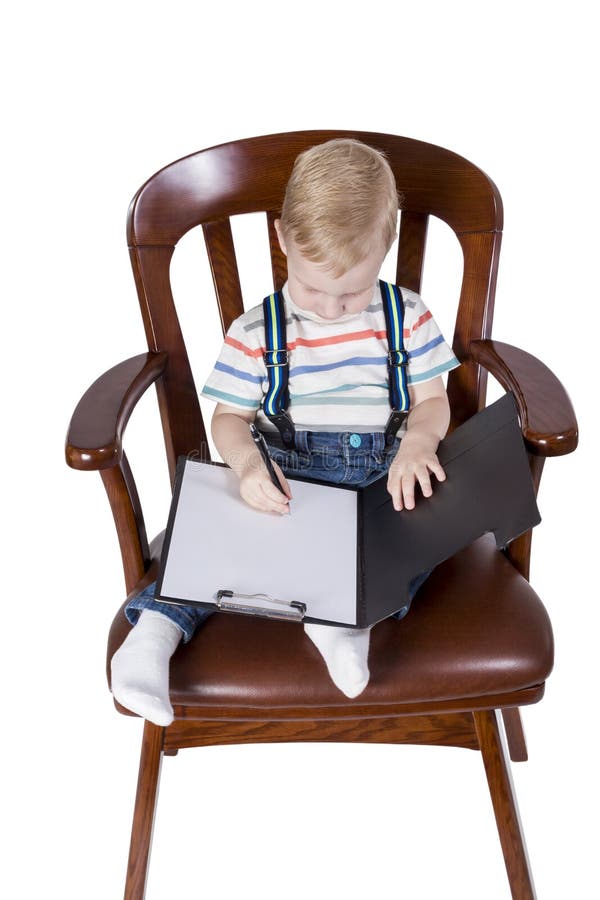 Petit garçon en tant que directeur dans la chaise image stock Petit garçon en tant que directeur dans la chaise image stock