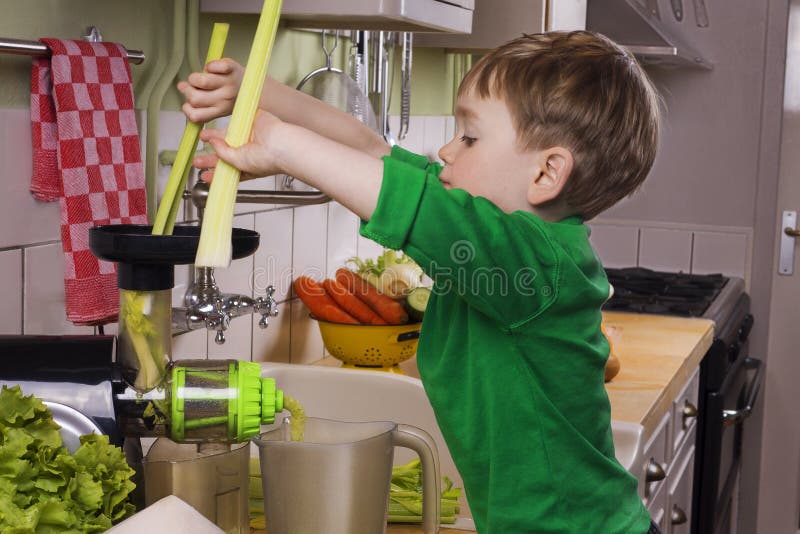 Petit garçon faisant le jus vert photos stock Petit garçon faisant le jus vert photos stock