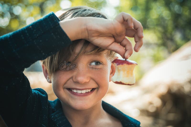 Petit garçon heureux drôle mangeant à une ferme Enfant appréciant la saison et rire d'automne Enfance heureux, concept de mode de photos stock Petit garçon heureux drôle mangeant à une ferme Enfant appréciant la saison et rire d'automne Enfance heureux, concept de mode de photos stock