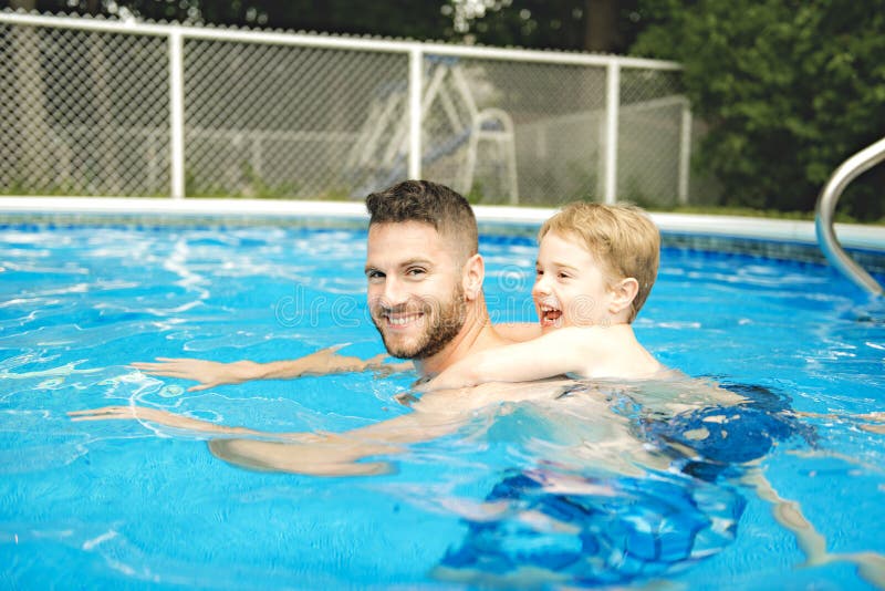 Petit garçon mignon apprenant à nager avec des parents dans la piscine photos libres de droits Petit garçon mignon apprenant à nager avec des parents dans la piscine photos libres de droits