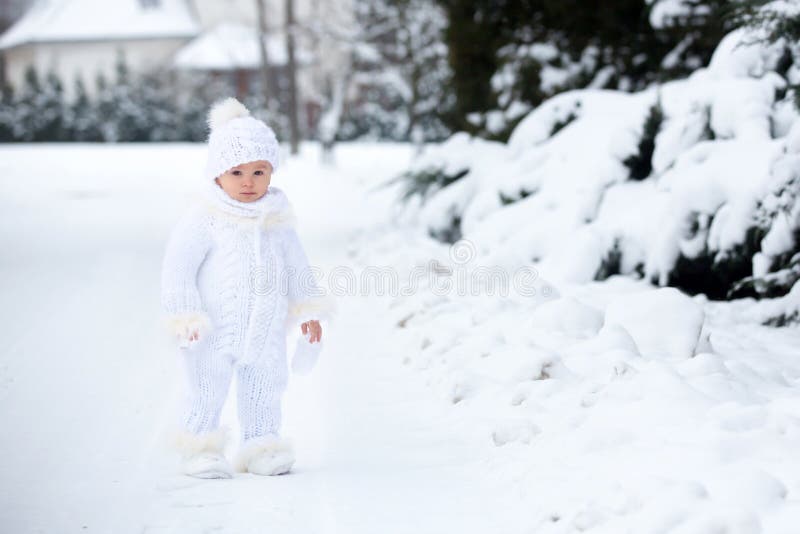 Petit garçon mignon d'enfant en bas âge, jouant dehors avec la neige un jour d'hiver photo libre de droits Petit garçon mignon d'enfant en bas âge, jouant dehors avec la neige un jour d'hiver photo libre de droits