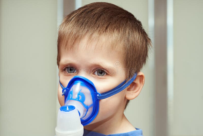 Petit garçon à l'aide d'un inhalateur image stock Petit garçon à l'aide d'un inhalateur image stock