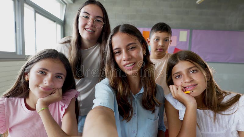Petit groupe d'enfants de l'école primaire prenant selfie vidéo portrait en classe banque de vidéos