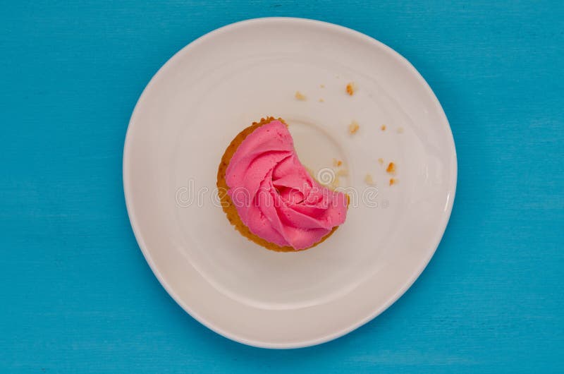 Petit gâteau mordu rose d'un plat d'isolement sur le fond bleu G?teau d?licieux Vue sup?rieure photo stock Petit gâteau mordu rose d'un plat d'isolement sur le fond bleu G?teau d?licieux Vue sup?rieure photo stock