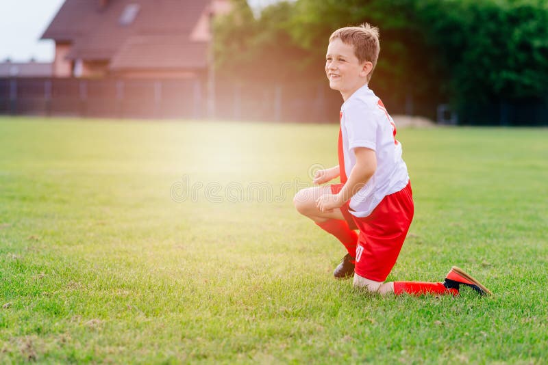 8 Ans Garçon Enfant Tenant Balle De Football Sur Terrain De Jeu