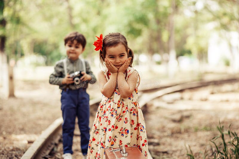 Petit modèle dans la robe de cru posant pour peu de photographe photographie stock libre de droits Petit modèle dans la robe de cru posant pour peu de photographe photographie stock libre de droits
