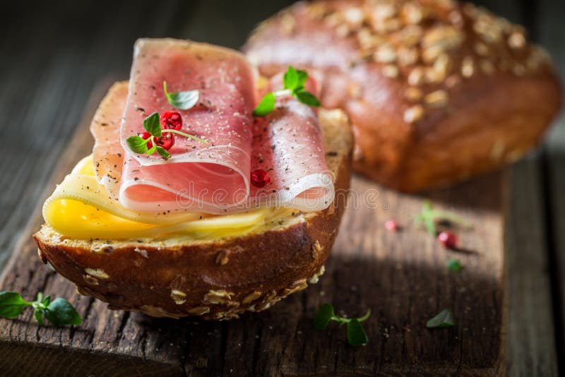Petit pain délicieux avec du jambon et le fromage pour le petit déjeuner photographie stock libre de droits Petit pain délicieux avec du jambon et le fromage pour le petit déjeuner photographie stock libre de droits