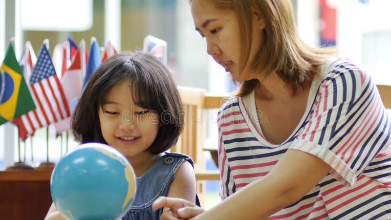 Petit étudiant asiatique regardant le globe