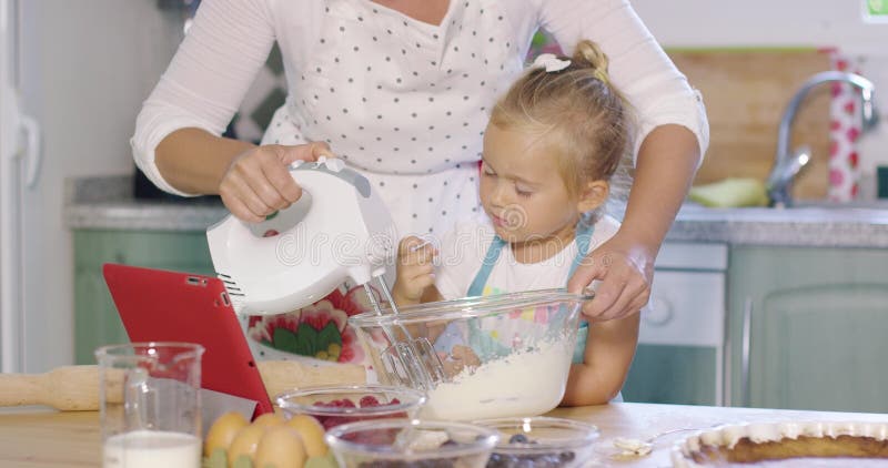 Petite aide mignonne de cuisine aidant sa maman