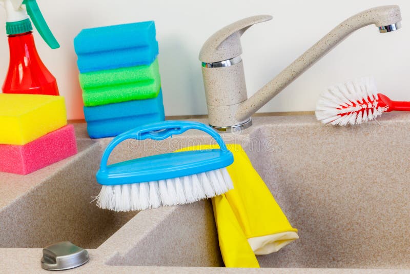 Petite brosse et éponges sur l'évier de cuisine près du robinet photographie stock Petite brosse et éponges sur l'évier de cuisine près du robinet photographie stock