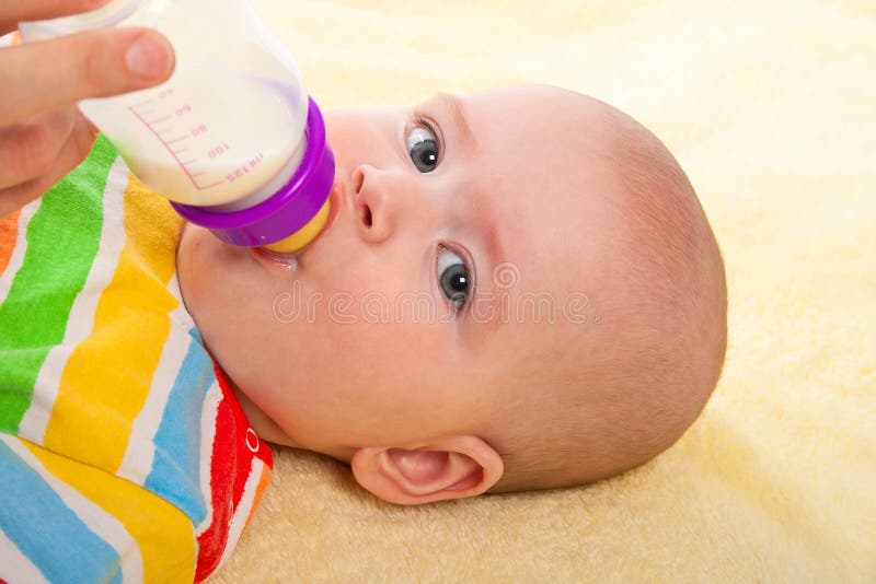 Petit bébé avec un biberon photo stock
