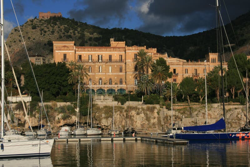 Palermo's Small Port, and quarter. Villa Igiea, Sailing boats & Mount Pelegrino with, on the top, Utveggio Castle. THe Grand Hotel Villa Igiea is one of the most famous spots in Sicily and in Italy, has stood looking out over the sea of Palermo. Projected in 1908 by Ernesto Basile, one of the greatest exponents of the Liberty. Palermo's Small Port, and quarter. Villa Igiea, Sailing boats & Mount Pelegrino with, on the top, Utveggio Castle. THe Grand Hotel Villa Igiea is one of the most famous spots in Sicily and in Italy, has stood looking out over the sea of Palermo. Projected in 1908 by Ernesto Basile, one of the greatest exponents of the Liberty