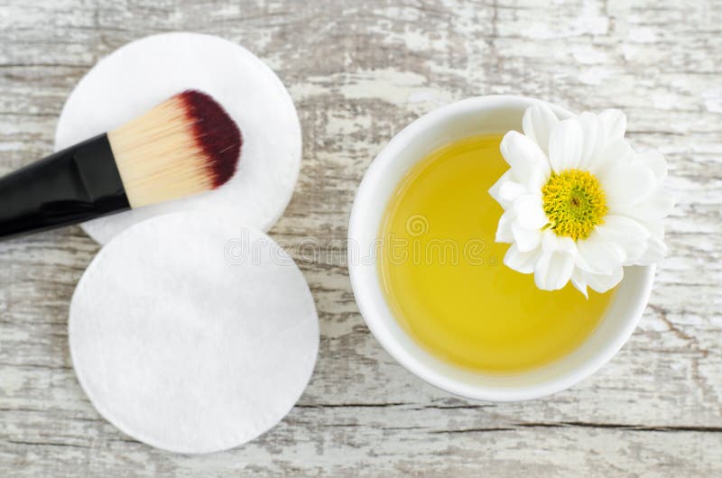 Petite cuvette blanche avec du cosmétique/le pétrole et protection de coton de nettoyage pour des soins de la peau naturels Cosmé image stock Petite cuvette blanche avec du cosmétique/le pétrole et protection de coton de nettoyage pour des soins de la peau naturels Cosmé image stock