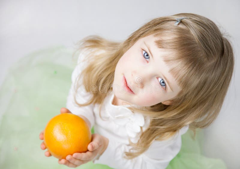 Petite fille adorable avec le pamplemousse mûr photo stock Petite fille adorable avec le pamplemousse mûr photo stock