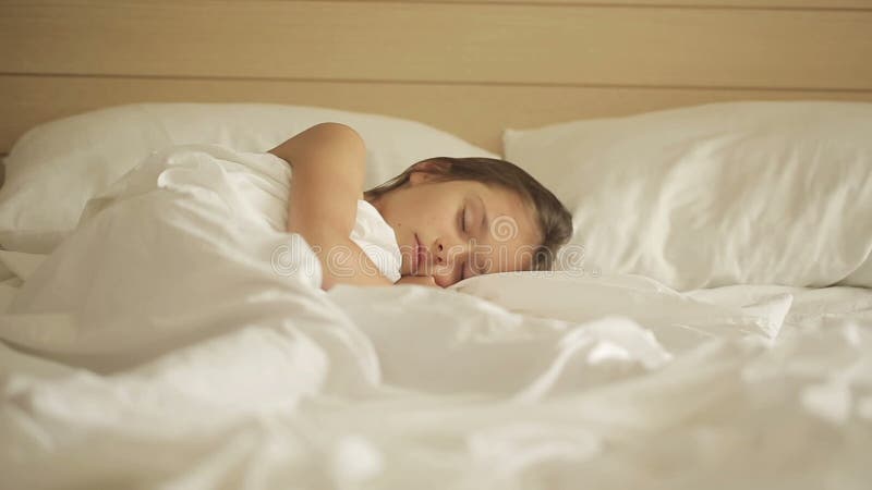 Petite fille adorable dormant dans un lit Chariot tiré juste vers la gauche banque de vidéos