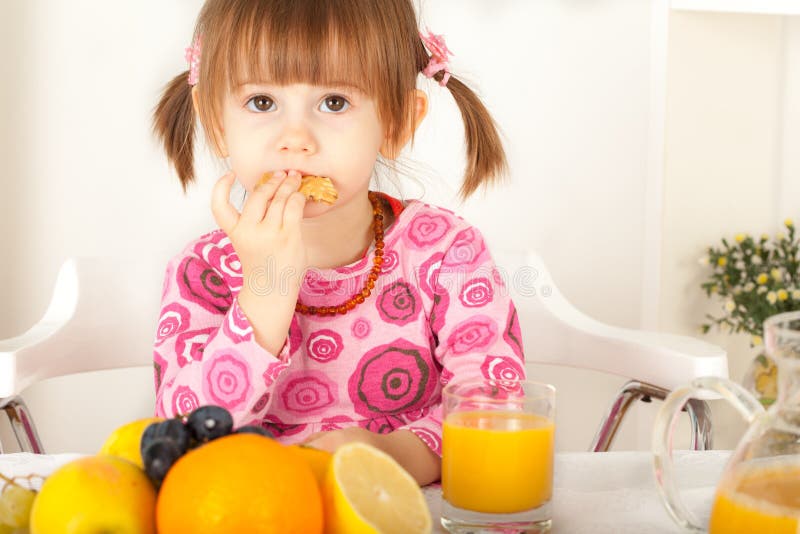 Petite fille adorable mangeant le biscuit photos stock Petite fille adorable mangeant le biscuit photos stock