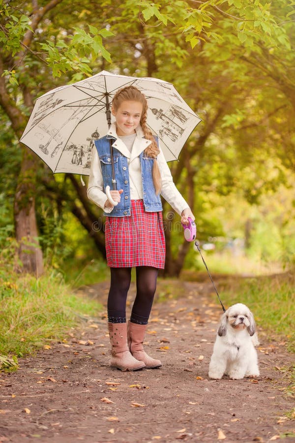 Petite fille adorable marchant avec le chien sous la pluie photos libres de droits Petite fille adorable marchant avec le chien sous la pluie photos libres de droits