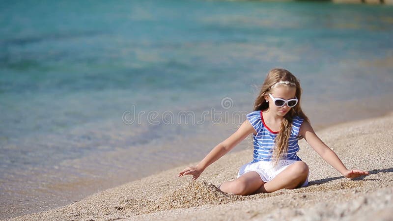 Petite fille adorable sur la plage pendant les vacances grecques banque de vidéos