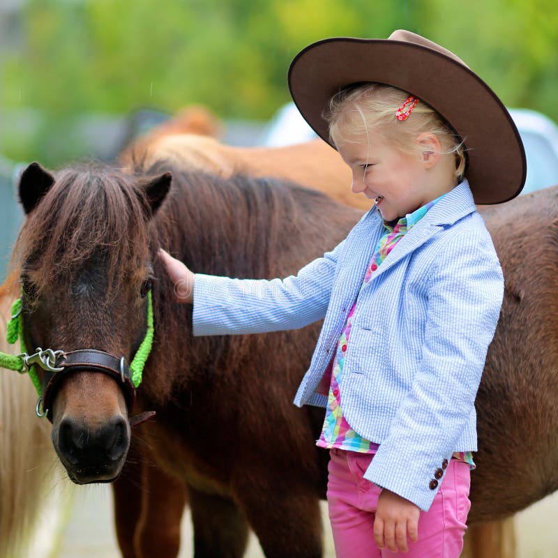 Petite fille appréciant son poney photos stock Petite fille appréciant son poney photos stock