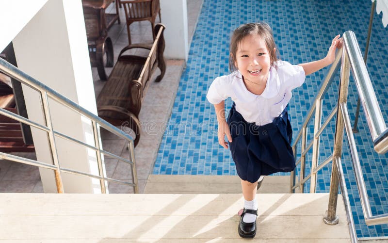 Petite fille asiatique allant les escaliers dans l'école