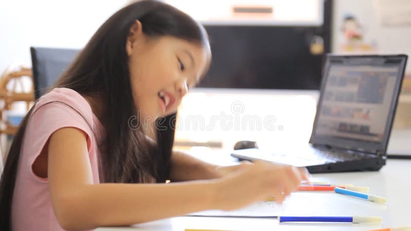 Petite fille asiatique dessinant une photo sur la table