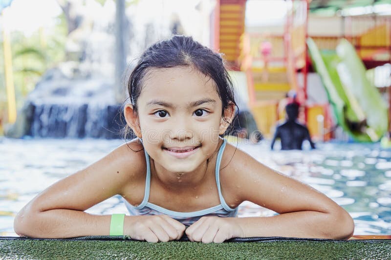 Petite fille asiatique heureuse ? la piscine photographie stock Petite fille asiatique heureuse ? la piscine photographie stock