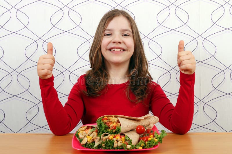 Petite fille avec des burritos nourriture et pouces mexicains photo stock Petite fille avec des burritos nourriture et pouces mexicains photo stock