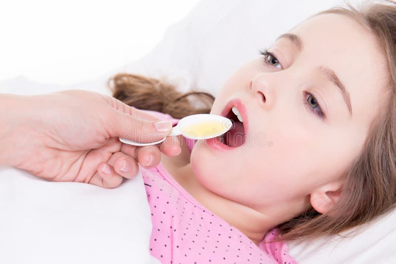 Petite fille avec l'angine utilisant le sirop de toux. photographie stock libre de droits