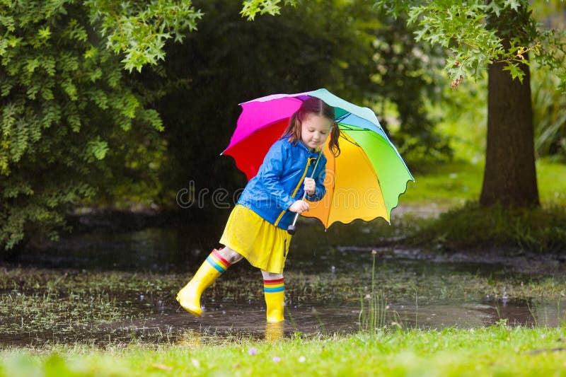 Petite fille avec le parapluie sous la pluie images stock Petite fille avec le parapluie sous la pluie images stock
