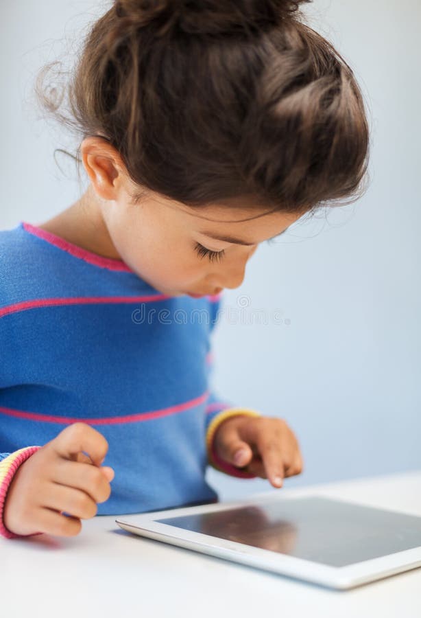 Petite fille avec le PC de comprimé images stock