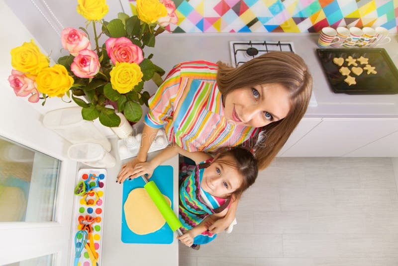 Petite fille avec sa mère préparant un biscuit sur la cuisine image libre de droits Petite fille avec sa mère préparant un biscuit sur la cuisine image libre de droits