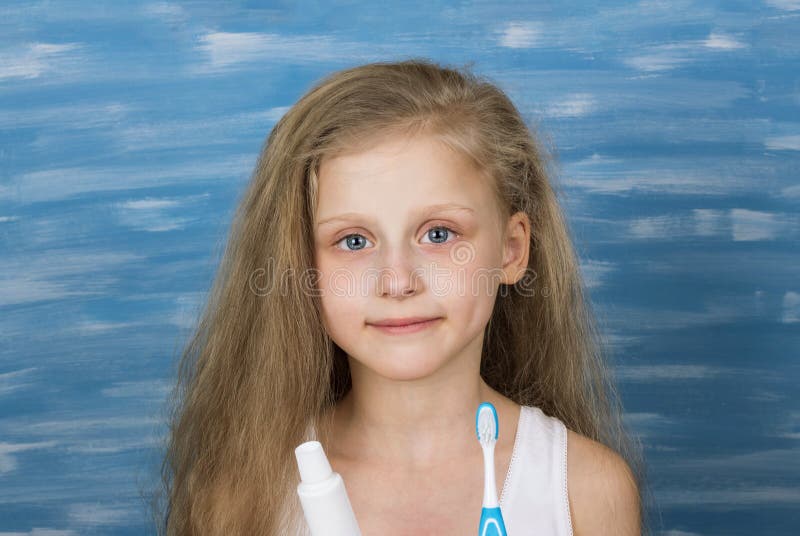 Petite fille blonde mignonne dans un T-shirt se brossant les dents dans la salle de bains photographie stock libre de droits Petite fille blonde mignonne dans un T-shirt se brossant les dents dans la salle de bains photographie stock libre de droits