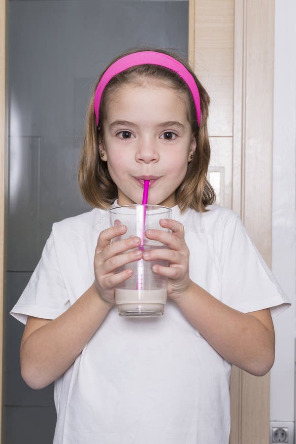 Petite fille buvant un verre de lait images stock Petite fille buvant un verre de lait images stock