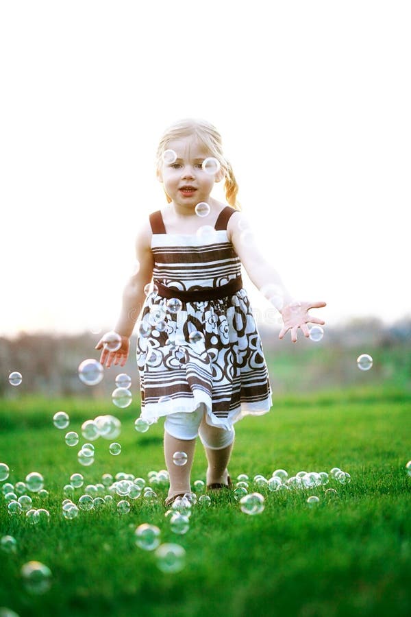 Petite Fille Chassant Des Bulles Photo stock - Image du bulles, vert ...