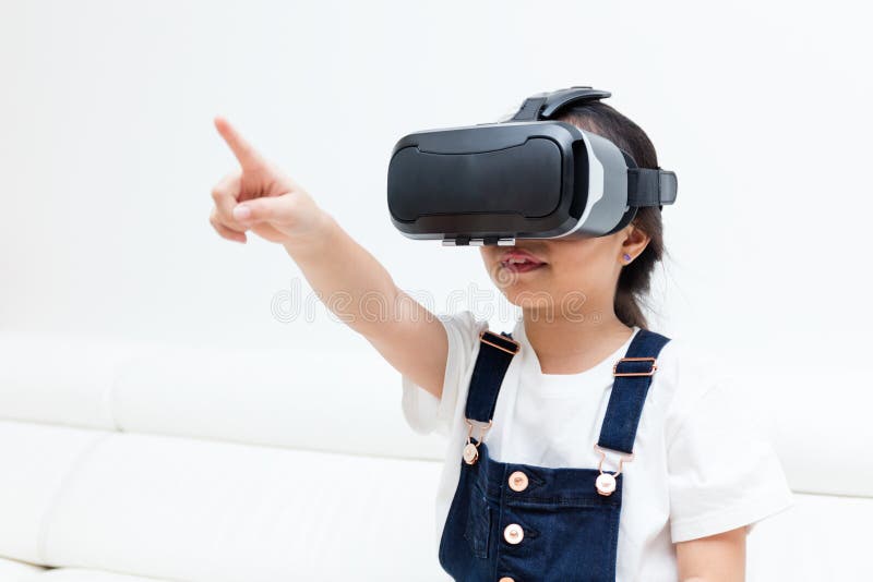 Petite fille chinoise asiatique éprouvant la réalité virtuelle à la maison photo libre de droits Petite fille chinoise asiatique éprouvant la réalité virtuelle à la maison photo libre de droits
