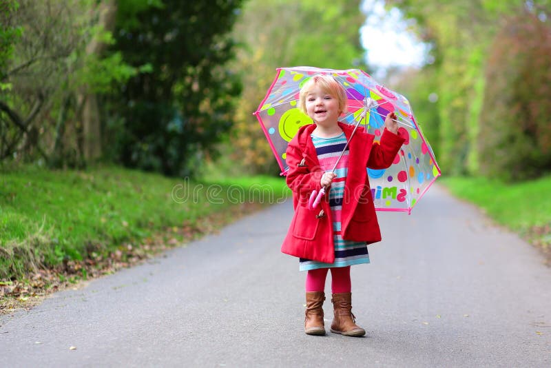 Petite fille d'enfant en bas âge marchant avec le parapluie photo stock Petite fille d'enfant en bas âge marchant avec le parapluie photo stock