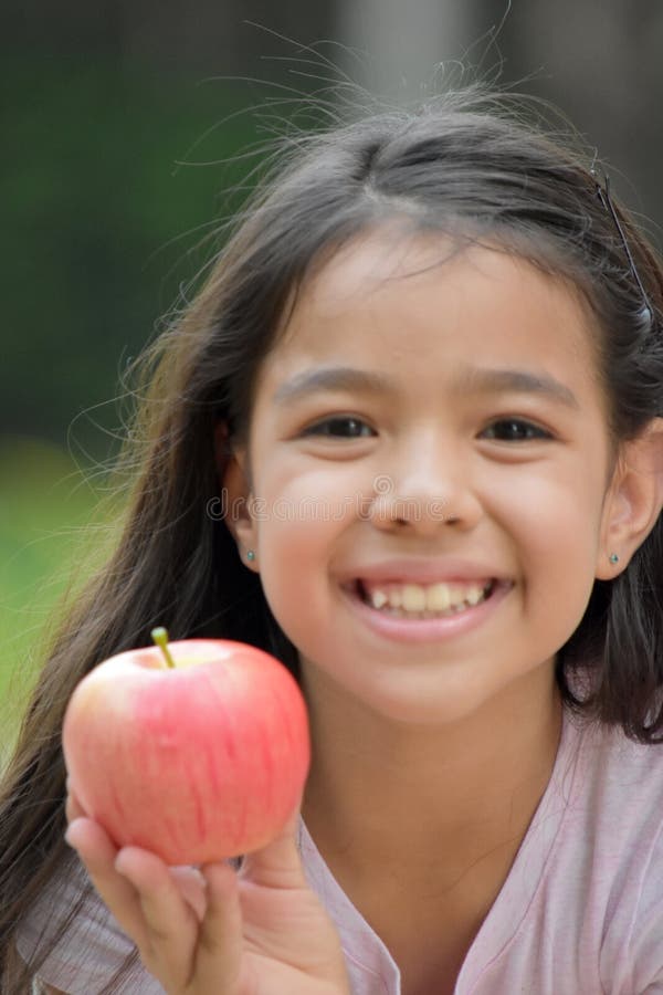 Petite fille de minorité souriant avec Apple photo libre de droits