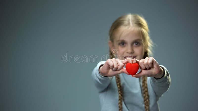 Petite fille de sourire montrant le chiffre de coeur dans le concept de cam?ra, d'amour et de gentillesse images libres de droits Petite fille de sourire montrant le chiffre de coeur dans le concept de cam?ra, d'amour et de gentillesse images libres de droits