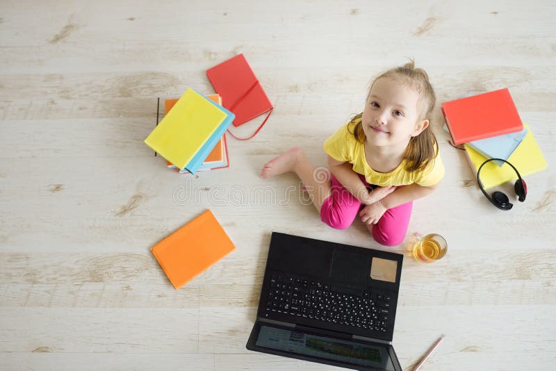 Petite Fille En Ligne Sur L'ordinateur Portable L'enfant Est Assis