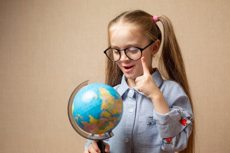 Petite fille en verres tenant le globe photo stock Petite fille en verres tenant le globe photo stock