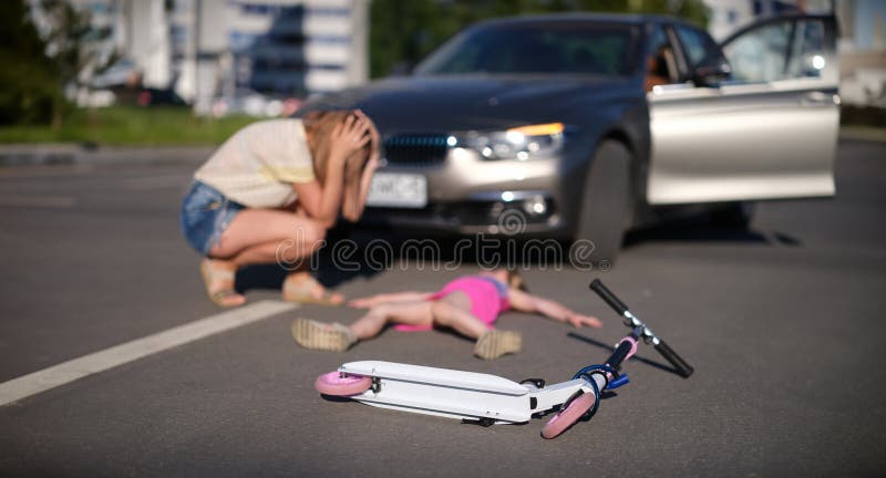 Petite fille est immobile sur l'asphalte avec scooter après collision voiture photo stock