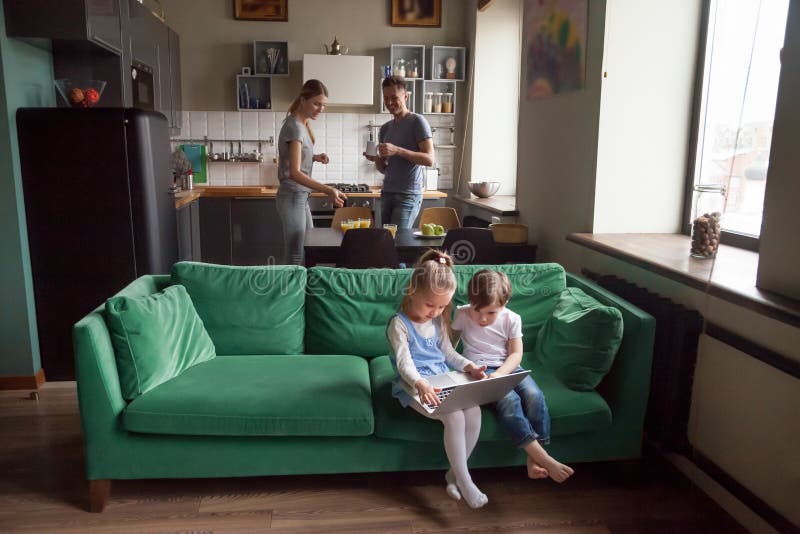 Petite fille et garçon employant parler de parents de moment d'ordinateur portable image libre de droits Petite fille et garçon employant parler de parents de moment d'ordinateur portable image libre de droits