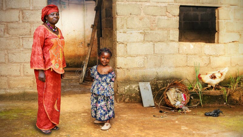 Black African little girl and her mother in traditional clothing at home. Black African little girl and her mother in traditional clothing at home