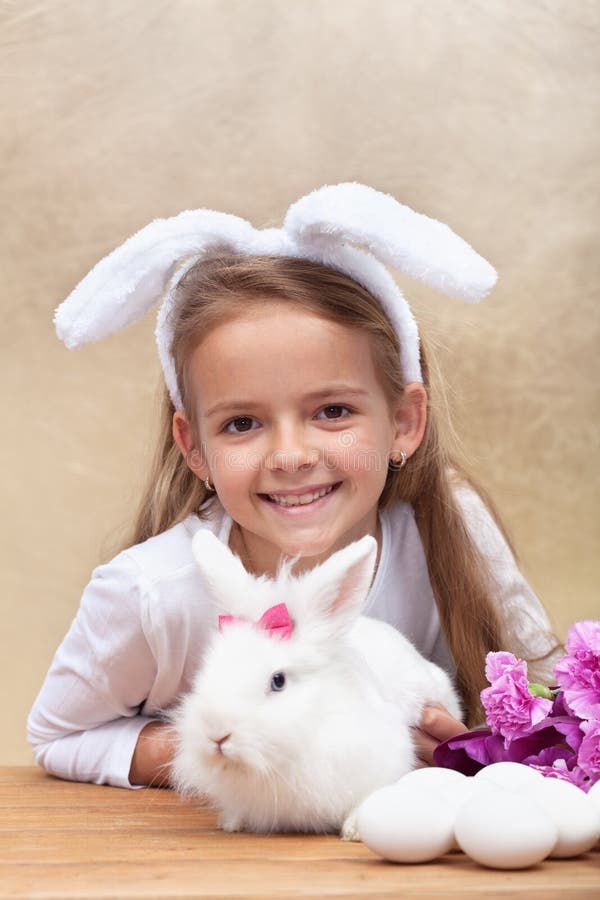 Petite Fille Heureuse Avec Les Oreilles De Lapin Et Son Lapin Blanc Mignon  Photo stock - Image du pelucheux, enfant: 49924072