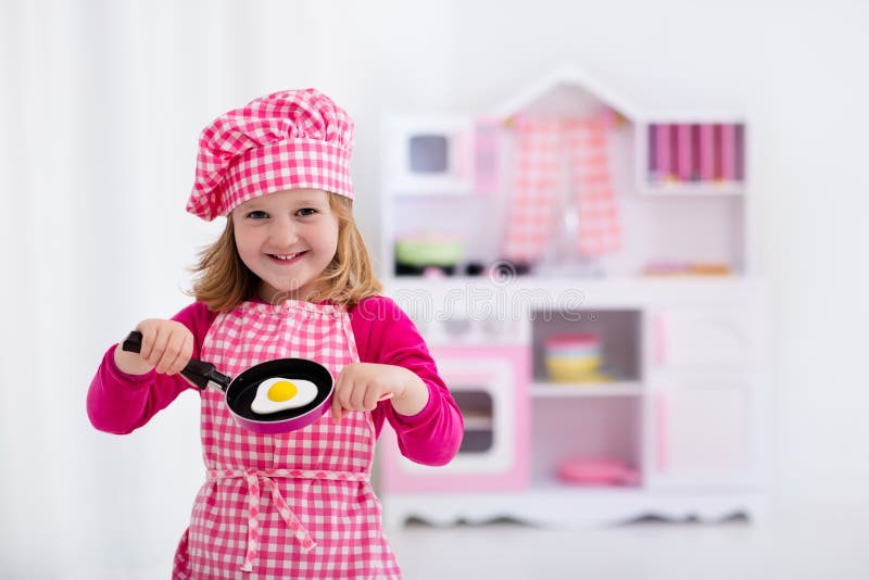 Petite Fille Jouant Avec La Cuisine De Jouet Image stock - Image du  chapeau, plaque: 73464053