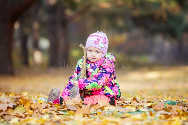 Petite fille jouant avec le dinosaure de jouet dehors photographie stock Petite fille jouant avec le dinosaure de jouet dehors photographie stock