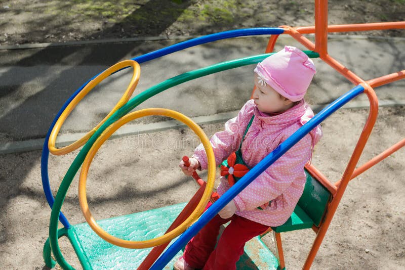 Petite fille jouant l'hélicoptère intérieur de barre de singe sur le terrain de jeu extérieur image stock