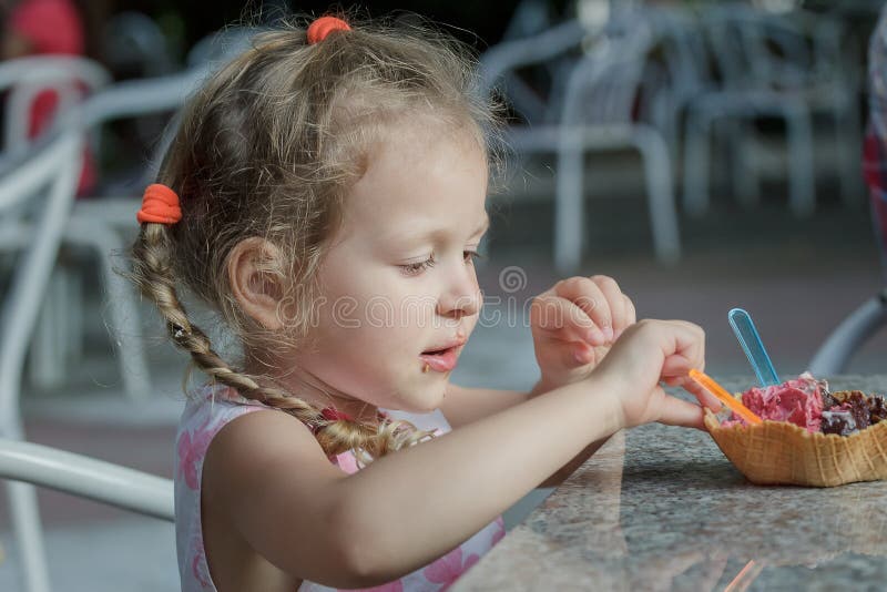 Petite fille mangeant son cône italien de gaufrette de crème glacée photos libres de droits